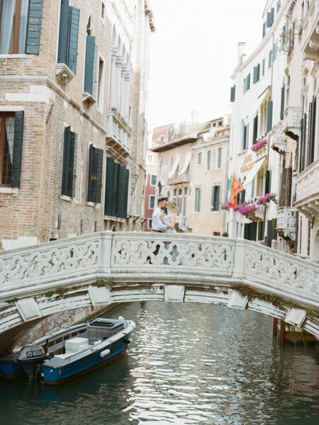 Wedding Photographer in Italy: Loving couple cuddles on the ancient bridge of Venice