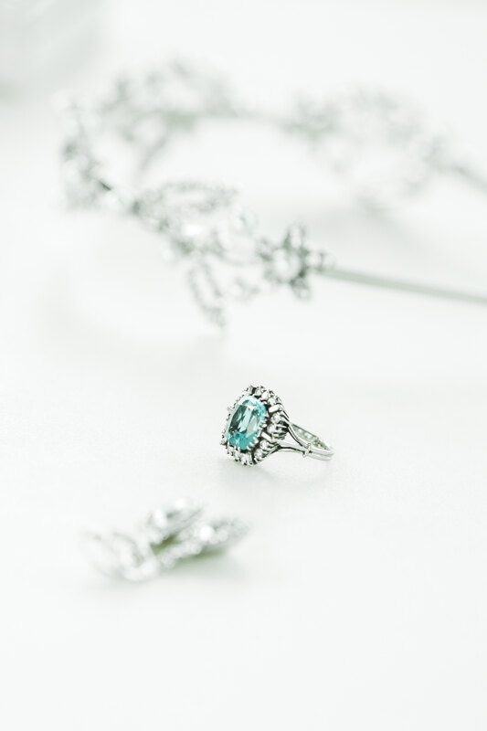 Wedding photography portfolio in Italy: Exquisite ring in white gold, decorated with small diamonds and a blue large stone in the middle