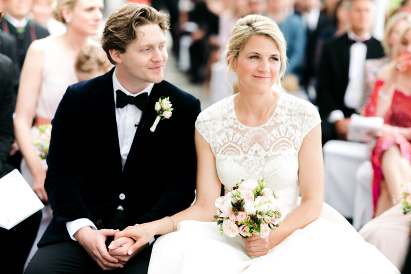 Wedding photography portfolio in Italy: Smiling newlyweds sitting holding hands