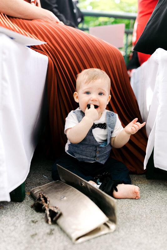 Wedding photography portfolio in Italy: Photo of a little boy in a suit sitting on the ground near mom