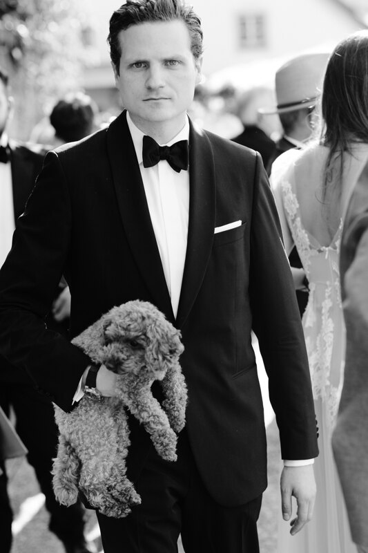 Wedding photography portfolio in Italy: Portrait of a man in a black tuxedo who holds his dog