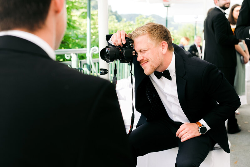 Wedding photography portfolio in Italy: A guest in a tuxedo takes pictures with his camera