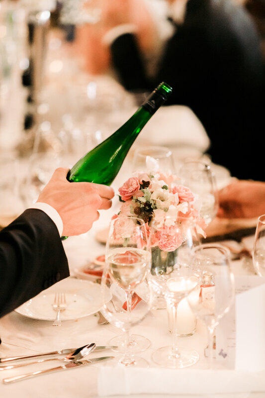 Wedding photography portfolio in Italy: A man holds in his hand a bottle of champagne and pours it into a glass