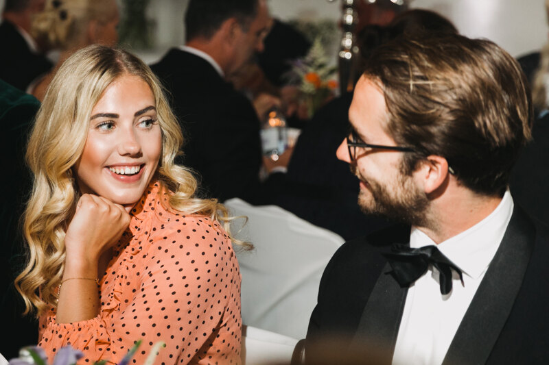 Wedding photography portfolio in Italy: Guests sincerely smile at the table and look at each other