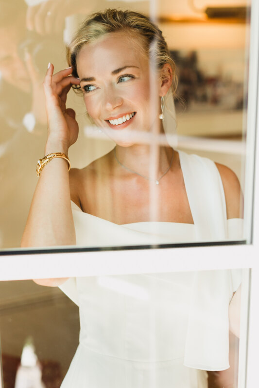 Wedding photography portfolio in Italy: Portrait of the bride through the glass, in which a slight reflection of the photographer is visible