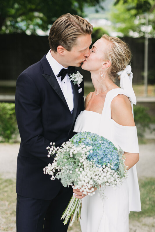 Wedding photography portfolio in Italy: The newlyweds kiss, the bride has a beautiful bouquet in her hands