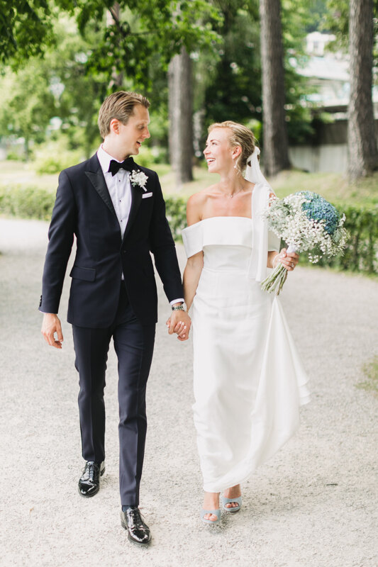 Wedding photography portfolio in Italy: Groom and bride go holding hands looking at each other and smiling