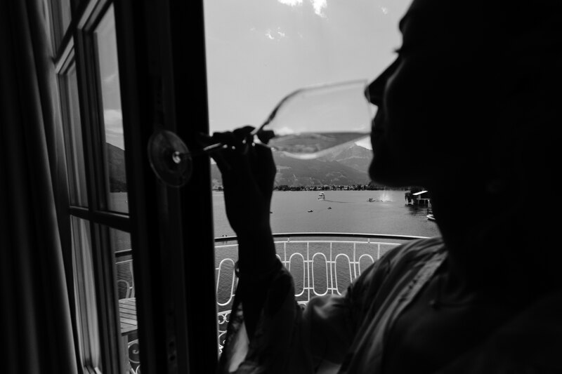 Wedding photography portfolio in Italy: Girl from a glass drinks champagne on the balcony