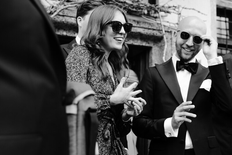 Wedding photography portfolio in Italy: Black and white photo of guests, a guy and a girl in glasses