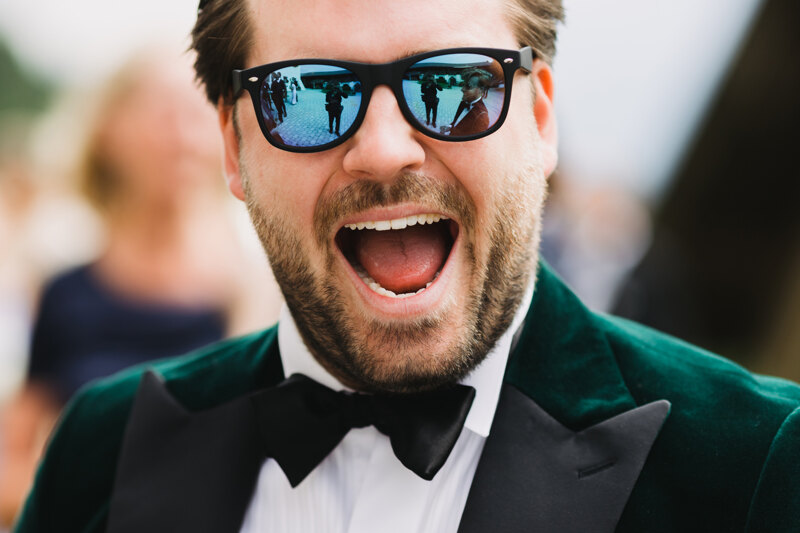 Wedding photography portfolio in Italy: Guest wearing black glasses and a bright green tuxedo