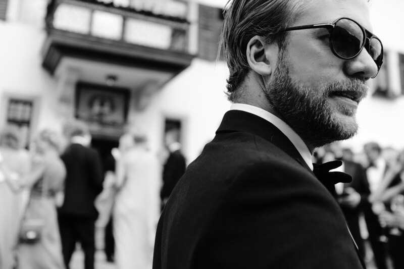 Wedding photography portfolio in Italy: Bearded guest in black glasses and a tuxedo.