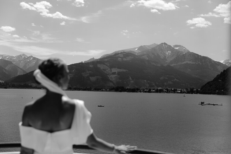 Wedding photography portfolio in Italy: The bride stands on the back side and enjoys a gorgeous view of the mountains and the lake.