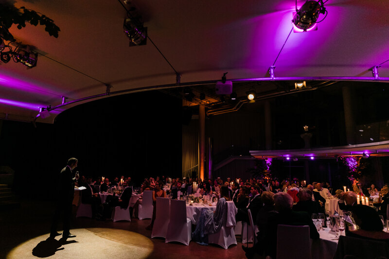 Wedding Photographer in Venice: a banquet room illuminated by professional light with round guest tables