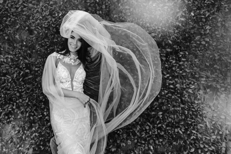 Wedding Photographer in Venice: Bride in a white dress waving a veil in the wind, posing for the photographer’s camera