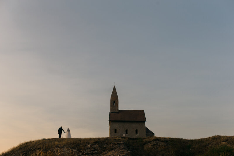 Wedding Photographer in Venice: Bride and groom holding hands on the background of the old church