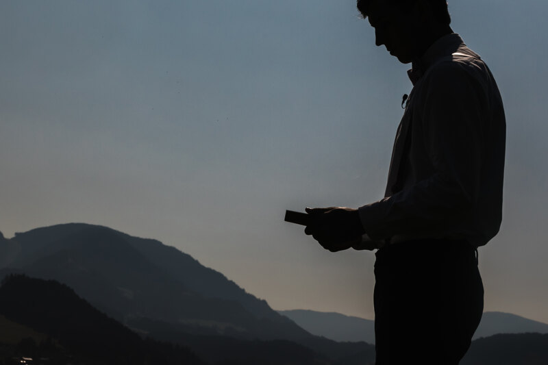 Wedding Photographer in Naples: Black and white portrait of the groom who is holding a book in his hands, on the background of endless and beautiful mountains
