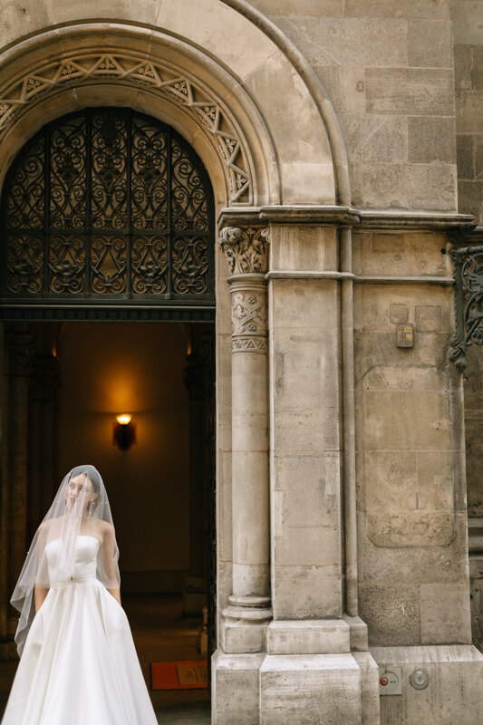 Wedding Photographer in Naples: Portrait of a Bride, whose veil covers her face, at the entrance to the Cathedral