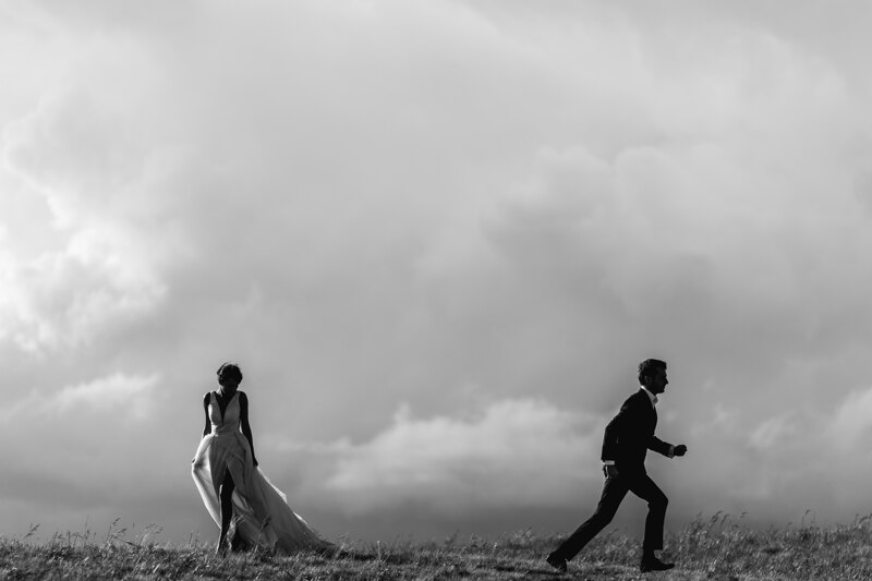 Wedding Photographer in Naples: Bride and Groom on the Horizon Between a Hill and a Cloudy Sky