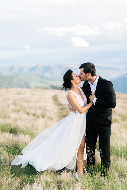 Wedding Photographer in Naples: Bride and groom kiss in a valley high in the mountains