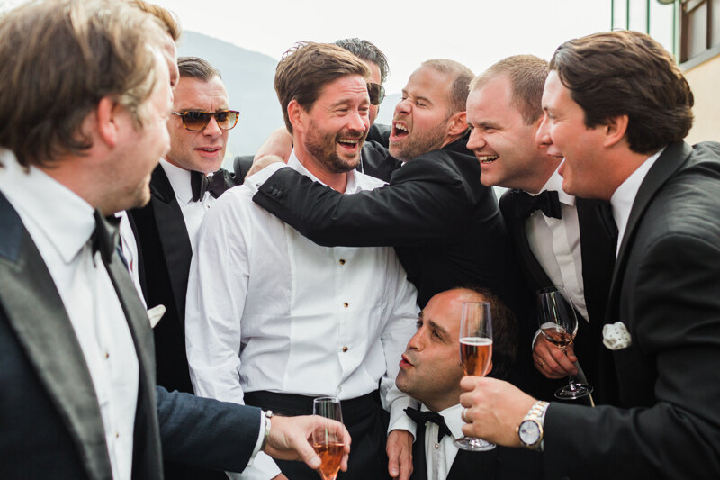 Wedding Photographer in Milan: Friends of the groom congratulate him on his marriage, with glasses of sparkling wine