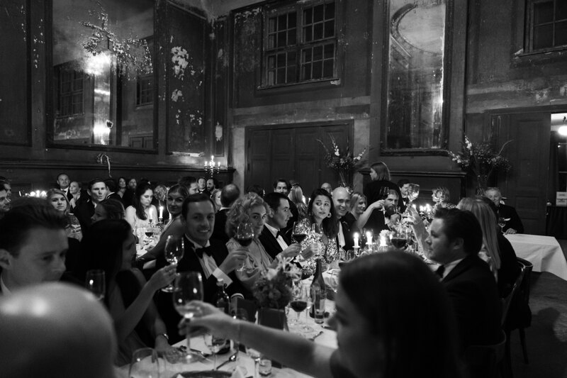 Wedding Photographer in Milan: Wealthy guests, in expensive tuxedos and luxurious dresses, have fun at a wedding in one of the old halls in Berlin