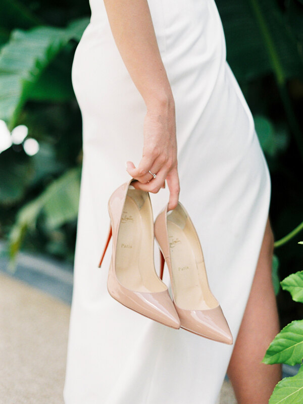 Wedding photography portfolio in Italy: The bride holds in her hands a very beautiful beige high-heeled shoes