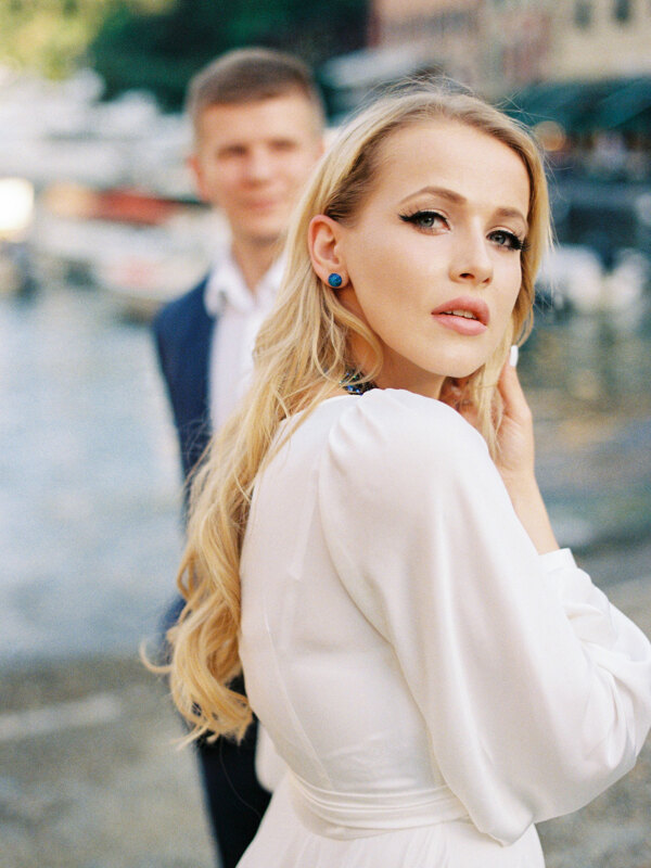 Wedding photography portfolio in Italy: Portrait of a beautiful blonde bride in a white dress with bright blue earrings