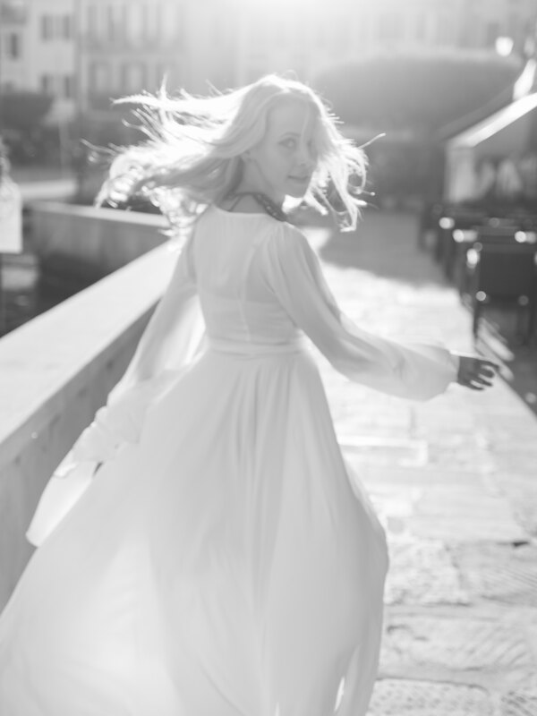 Wedding photography portfolio in Italy: The bride in a white dress, her hair is gently dispelled by the wind