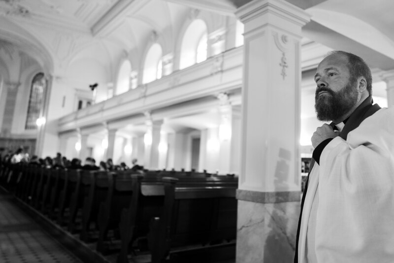 Wedding photography portfolio in Italy: The priest straightens his cassock, and prepares for the ceremony
