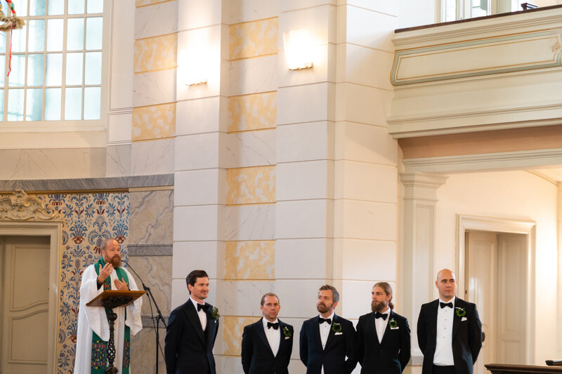 Wedding photography portfolio in Italy: The priest, the groom and his friends, stand in the ceremony hall
