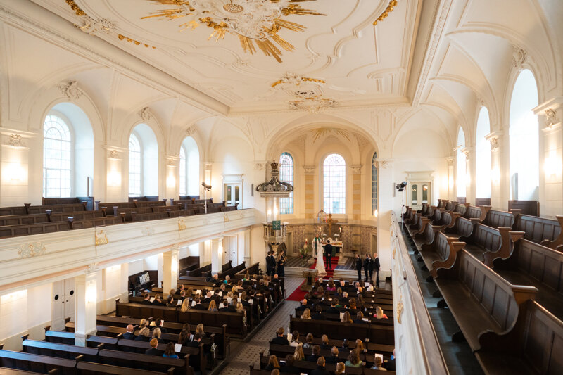 Wedding photography portfolio in Italy: The large, old church is filled with people who attend the wedding ceremony.