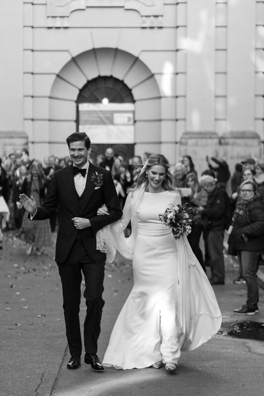 Wedding photography portfolio in Italy: Beautiful and smiling young couple of newlyweds go under stormy applause of guests