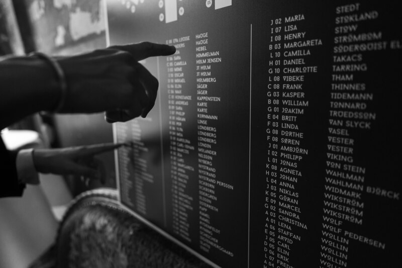 Wedding photography portfolio in Italy: Guests are hand-searching for their place at the table in the guest seating lists