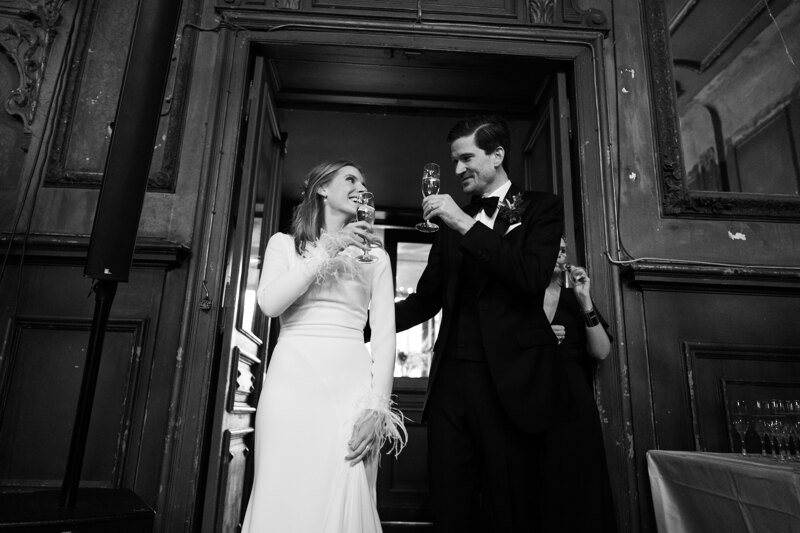 Wedding photography portfolio in Italy: The bride and groom hold glasses with champagne in their hands and look at each other