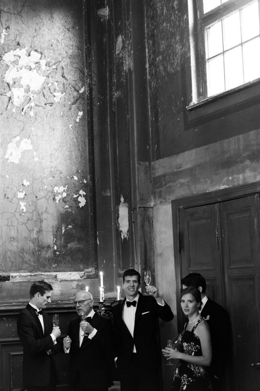 Wedding photography portfolio in Italy: Guests chatting among themselves in the hall and drinking champagne