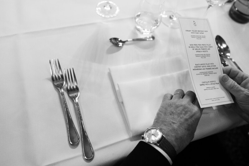 Wedding photography portfolio in Italy: A man holds a card with a menu in his hands