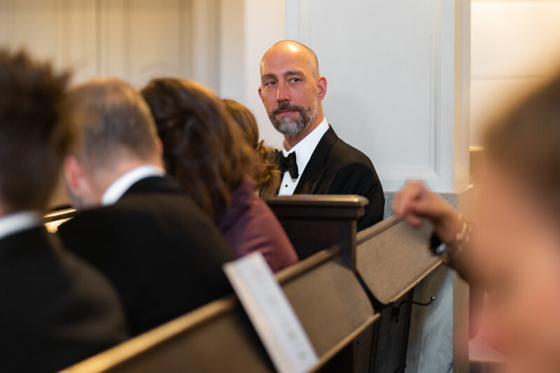 Wedding photography portfolio in Italy: Guest sits on a bench in the hall