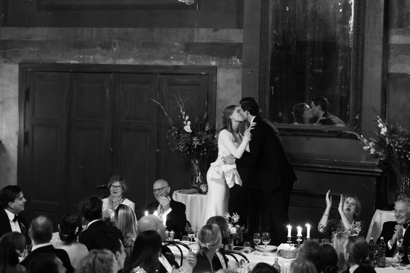 Wedding photography portfolio in Italy: The bride and groom kiss to the applause of the guests in the hall