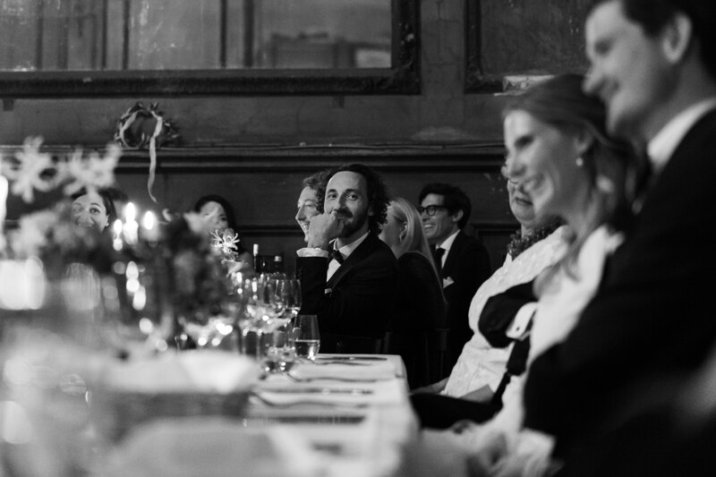 Wedding photography portfolio in Italy: A man sits at a table and looks at the photographer’s camera