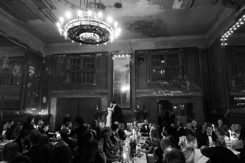 Wedding photography portfolio in Italy: The bride and groom kiss passionately under the applause of the guests