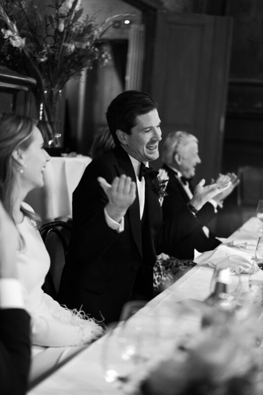 Wedding photography portfolio in Italy: The groom is sitting at a table shrug