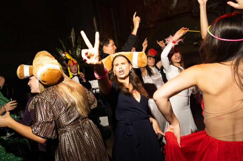 Wedding photography portfolio in Italy: Guests have fun and dance with various accessories on their heads