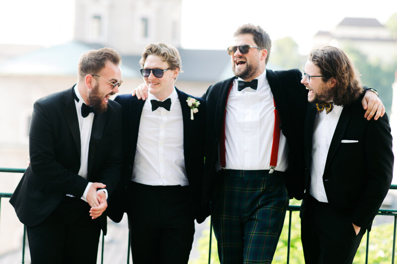 Wedding photoshoot in Italy: Groom and his friends have fun chatting on the balcony
