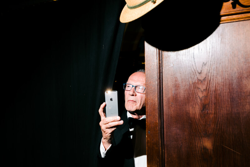 Wedding photoshoot in Italy: A man in a suit takes pictures on his phone