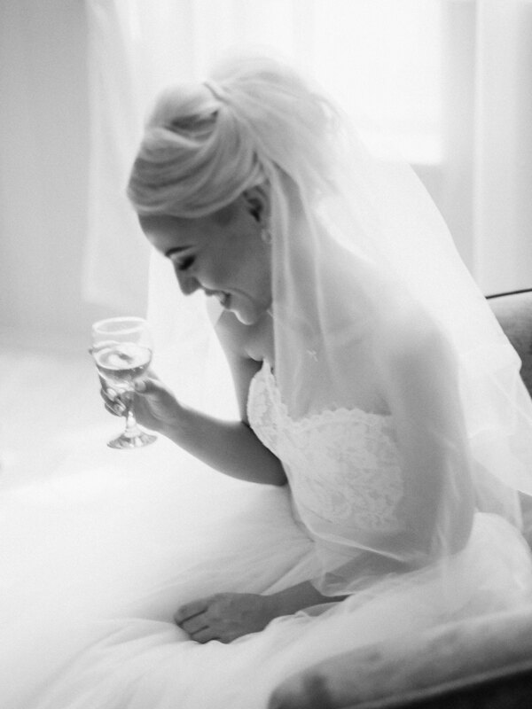 Wedding photoshoot in Italy: Morning of a fragile bride who sincerely smiles with a glass of sparkling