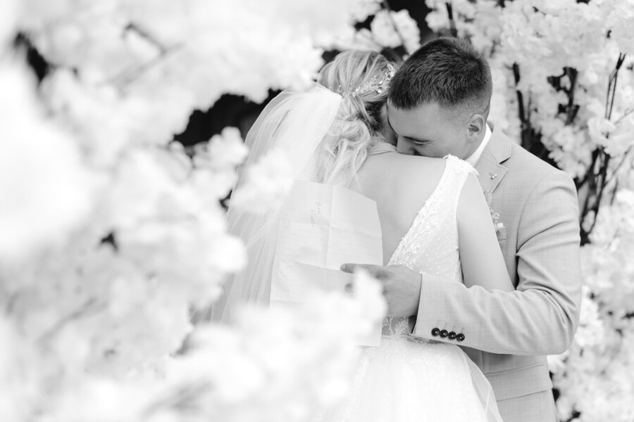 Services of Wedding Photographer in Italy: The groom sincerely hugs his bride, after the words of the vow that are written on the sheet in his hands
