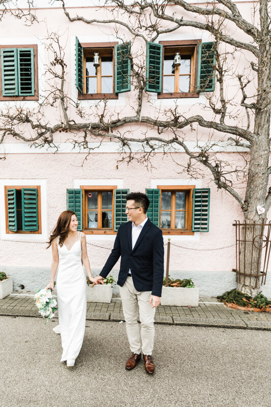 Couple photoshoot in Italy: A happy, loving couple holding hands against the background of an interesting house, on the walls of which a large tree grows