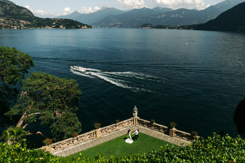 Couple photoshoot in Italy: A wide frame that shows a couple of newlyweds who are standing in the courtyard of a luxury villa on Lake Como