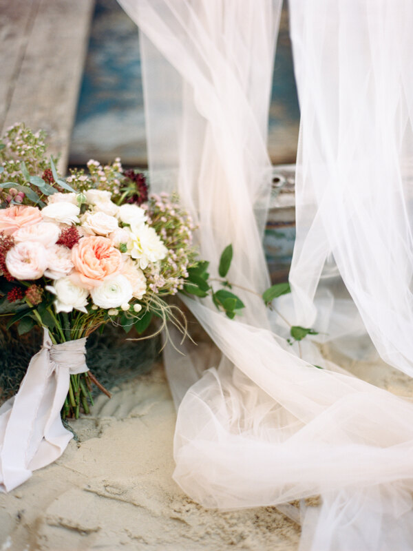 Couple photoshoot in Italy: A delicate bridal bouquet with powdery roses tied with a silk ribbon