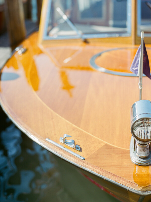 Couple photoshoot in Italy: An old, but luxurious, wooden boat with exclusive metal details that floats through the narrow canals of Venice